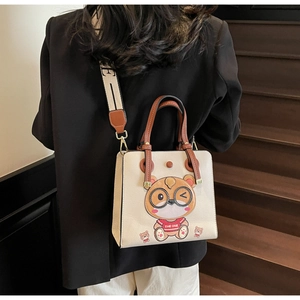 Detail of off-white lychee texture tote bag with cartoon character on leather
