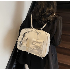 Dettaglio dello zaino stile balletto bianco panna con fiocchi e ciondolo a cuore