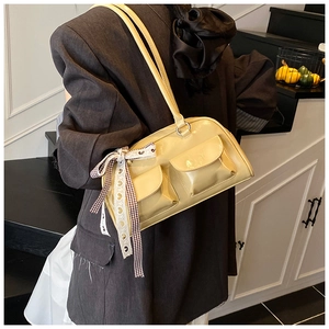Detail of yellow oil wax leather shoulder bag with side bow and front flap pockets