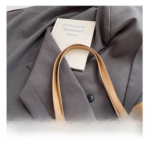 Detailed close-up of woven tote bag featuring beige texture and camel leather handles