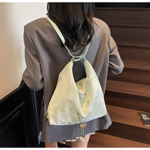 Detail of mint green satin backpack with ribbon straps and pearl butterfly charms