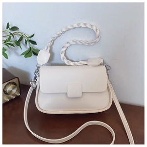 Detail of white PU leather crossbody bag featuring diamond woven texture and silver hardware