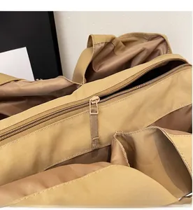 Close-up of smooth metal zipper and brown satin lining on khaki nylon tote bag