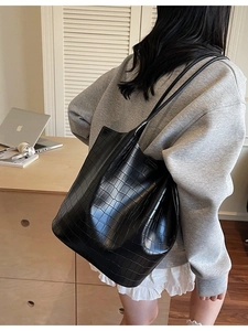 Fashionable black crocodile pattern bucket bag with double shoulder straps on model