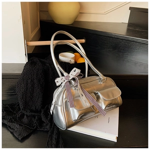 Detail of silver pillow bag with metallic finish, double pockets and lace bow ornament
