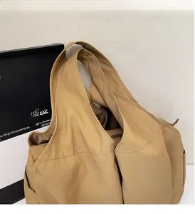 Detail of khaki large capacity tote bag with wide shoulder strap and multi-pocket design