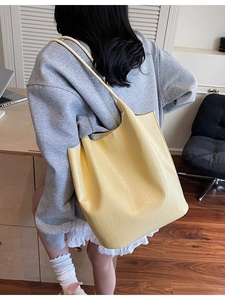 Fashionable pale yellow bucket bag with crocodile texture and long shoulder strap for women