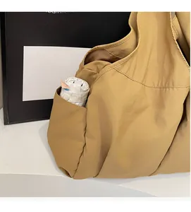 Detail view of khaki tote bag side pocket holding a small folding umbrella