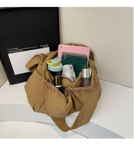 Close-up showing a large camel tote bag holding a tablet, bottle, and daily items