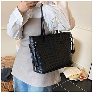 Close-up of black leather woven tote bag with classic Intrecciato pattern and thin straps