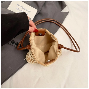 Détail du sac seau en paille tissée montrant le fermoir magnétique et la doublure