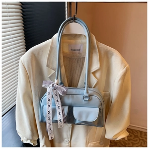 Detail of light blue PU leather pillow bag with dual pockets and decorative silk scarf
