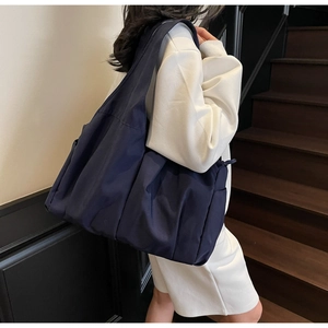 Gros plan d'un grand sac cabas bleu marine en nylon avec poches latérales et fermeture