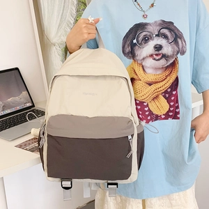 Detail of color-block nylon backpack featuring a front pocket and durable drawstring