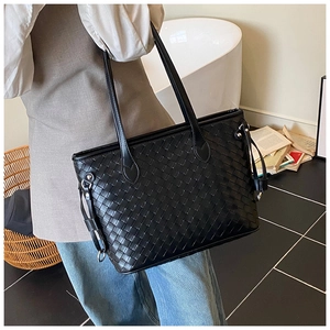 Detail of black woven leather tote bag showing intricate texture and luxury craftsmanship