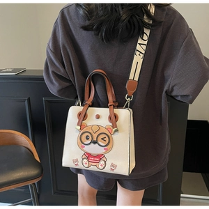 Detail of crossbody tote bag with wide 'LOVE' strap and cartoon character pattern