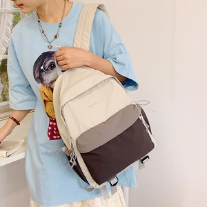 Close-up of color-block nylon backpack with adjustable drawstring side detail
