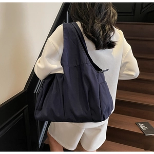 Vue détaillée du sac cabas en nylon bleu foncé avec larges bretelles pour le trajet