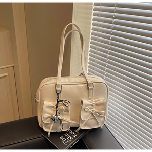 Dettaglio dello zaino color crema stile balletto con tasche a fiocco e ciondolo a cuore