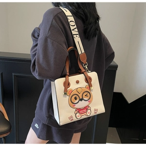Detail of a large cream tote bag with cartoon bear print and LOVE lettered wide strap