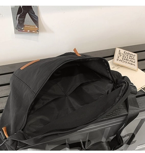 Vue détaillée de l'intérieur spacieux du sac bandoulière noir avec compartiments de rangement