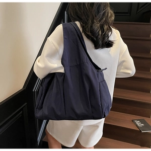 Vue détaillée du sac fourre-tout en nylon bleu marine avec fermeture éclair et poche