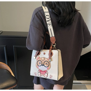 Detail of off-white tote bag with cartoon bear and wide LOVE printed shoulder strap