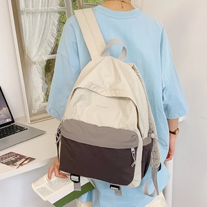 Detail of nylon backpack showing contrast color stitching and side drawstring mechanism