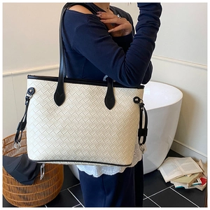 Detail of large woven tote bag in cream and black leather on a fashion model
