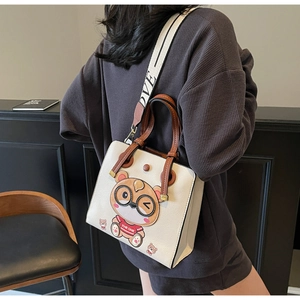 Detail of cream tote bag featuring a cute 3D bear motif and patterned wide strap
