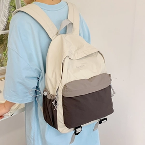 Close-up of color-block nylon backpack with adjustable side drawstring and embroidery details