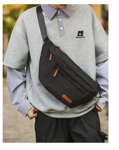 Détail du sac bandoulière noir avec multiples fermetures éclair et tirettes en cuir élégantes