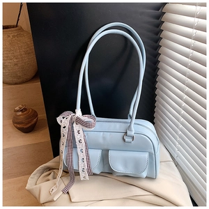 Detail of light blue underarm bag with multi-pocket design and lace bow accessory