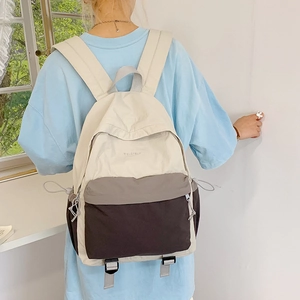 Rear view of minimalist color-block nylon backpack with drawstring side pockets and soft tones