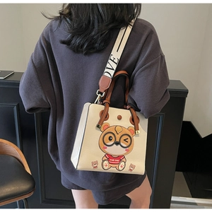 Detail of a beige tote bag featuring a cool bear pattern and wide LOVE strap
