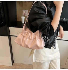 Gros plan détaillé du sac nuage plissé rose avec finition brillante et détails argentés