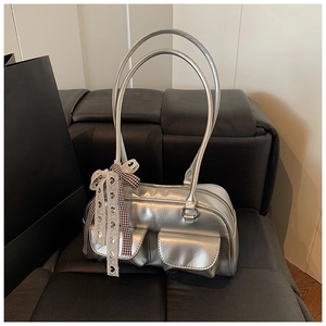 Macro shot of silver metallic bowling bag featuring dual front pockets and a ribbon bow