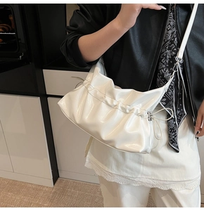 Vue détaillée du sac nuage blanc plissé avec finition brillante et fine bandoulière réglable