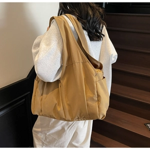Vue détaillée d'un grand sac cabas jaune moutarde avec poches latérales et large sangle