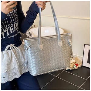Detail of silver woven texture tote bag with leather craftsmanship and metal hardware