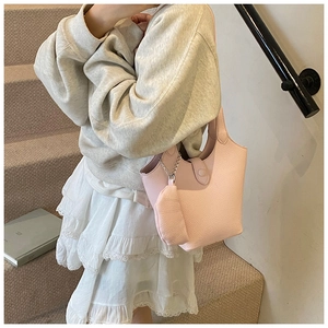 Pink lychee texture bucket bag with mini zip pouch and silver chain detail on a model