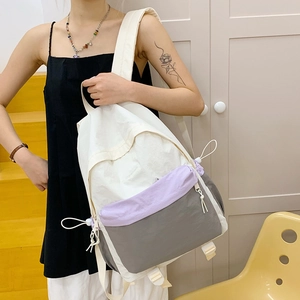 Close-up of color-block nylon backpack with adjustable buckles on a model