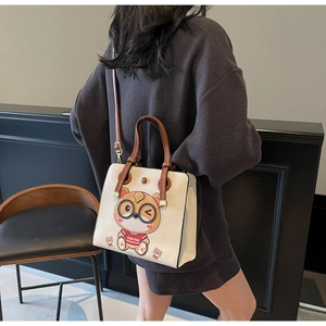 Detail view of tote bag with cartoon bear pattern and adjustable brown shoulder strap