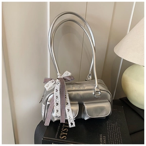 Detail of silver metallic shoulder bag with double pockets and lace bow decoration