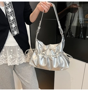 Sac nuage argenté plissé porté par un mannequin montrant la texture métallisée et cordon
