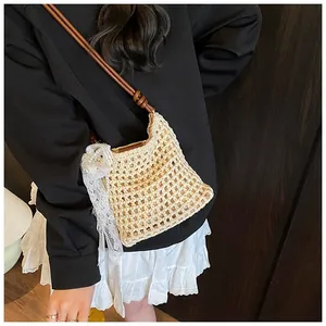 Détails de la texture du sac en crochet beige avec nœud en dentelle et perles
