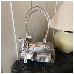 Detail of silver metallic shoulder bag with double pockets and lace bow decoration