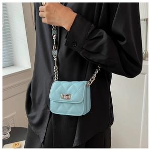 Close-up of light blue quilted mini crossbody bag with silver chain strap and metal buckle