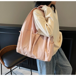 Vue détaillée du sac cabas en nylon rose montrant la poche latérale et la structure