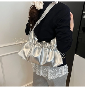 Détail du sac nuage plissé argenté avec bandoulière réglable porté par un mannequin